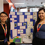 Deux participants devant leur panneau de projet.