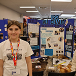 Two participants standing in front of their project board.