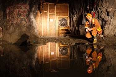 Un mineur examine un bassin d'eau souterrain au site de la mine Giant.