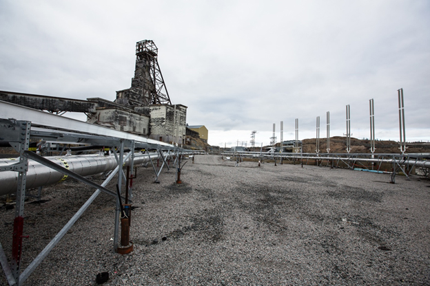 Le chevalement du puits de la mine Giant avec, en avant-plan, des tuyaux utilisés pour la méthode des blocs congelés.